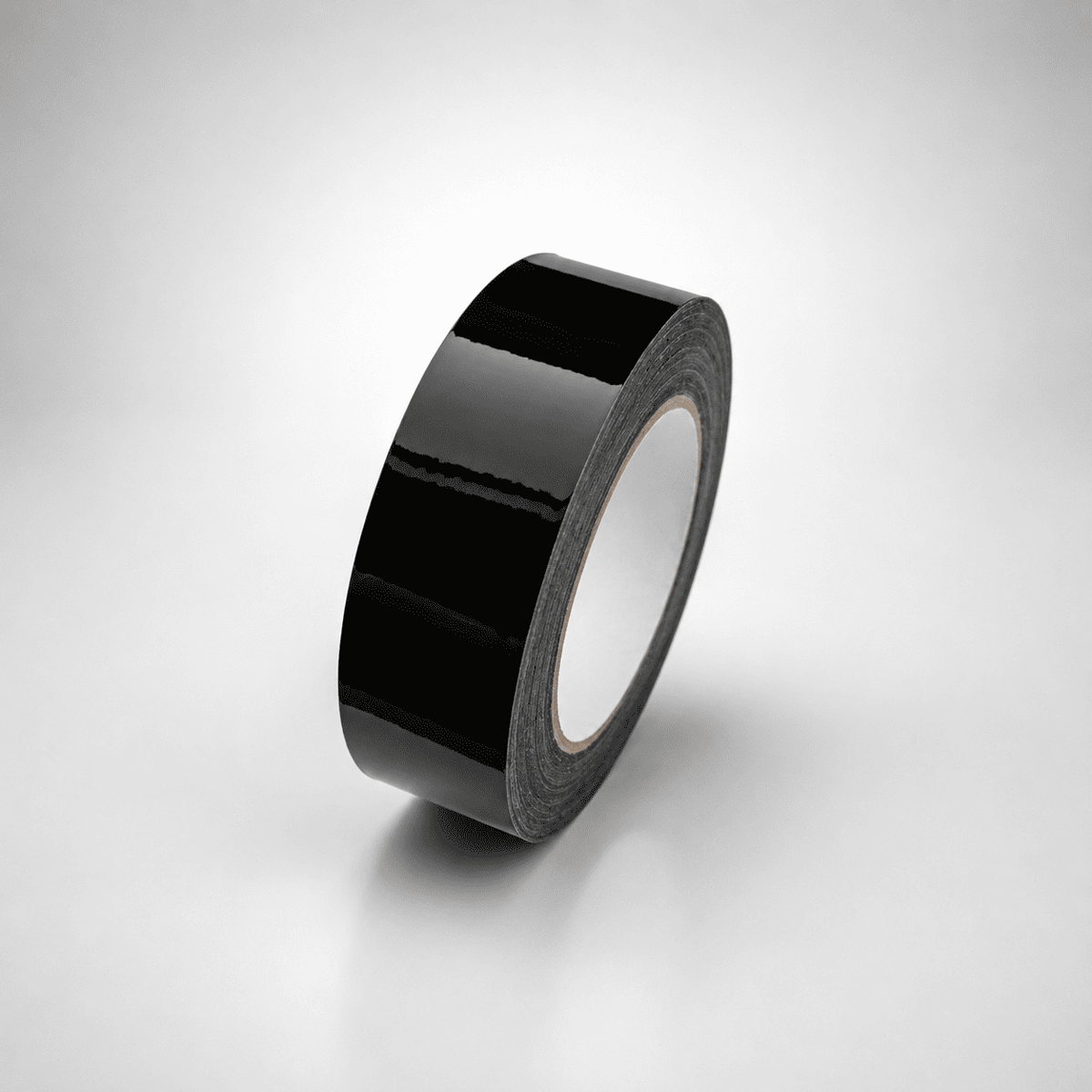 A roll of glossy black tape standing upright on a light gray gradient background.