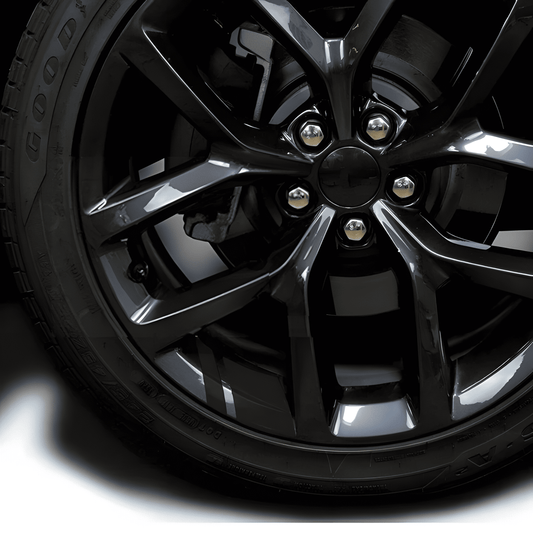 A sleek black reflective rim decal strip applied to a black alloy wheel, blending seamlessly for a stealthy, premium look. Designed to enhance nighttime visibility while maintaining a clean, subtle appearance, these waterproof stickers fit 18'' - 21'' rims for cars and motorcycles.