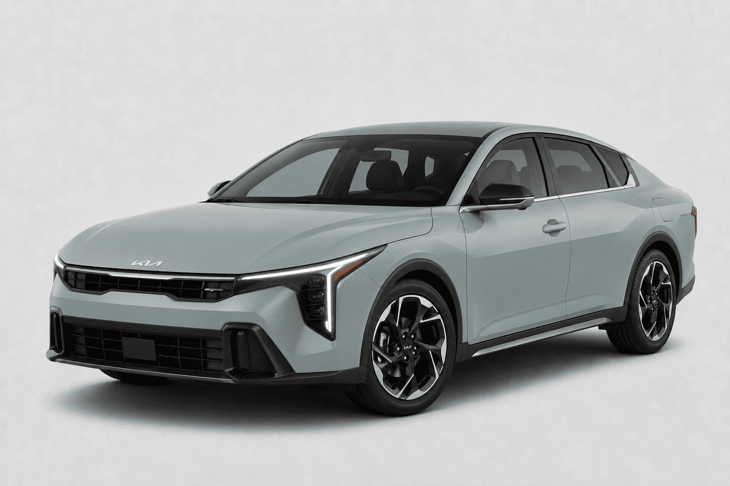 A light gray Kia sedan shown at a three-quarter front angle on a clean, light gray studio background.
