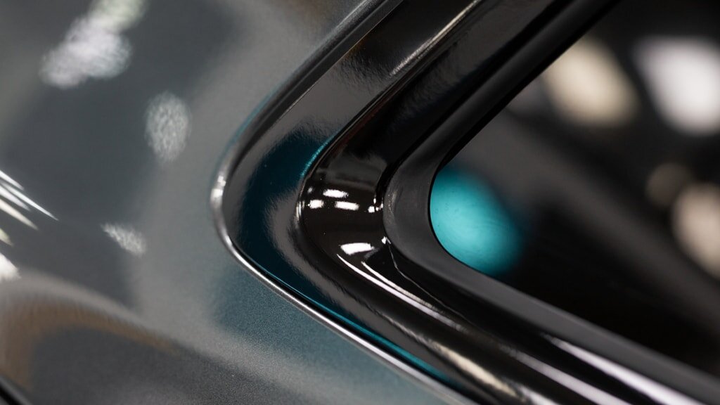 A close-up of a car's black window trim, highlighting the precision and clean application of ChroMorpher vinyl tape.