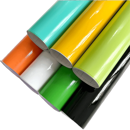 A collection of vibrant ChroMorpher Colorful Gloss Vinyl Rolls in various colors including orange, white, green, black, yellow, and mint, showcasing their glossy finish and high-quality material.