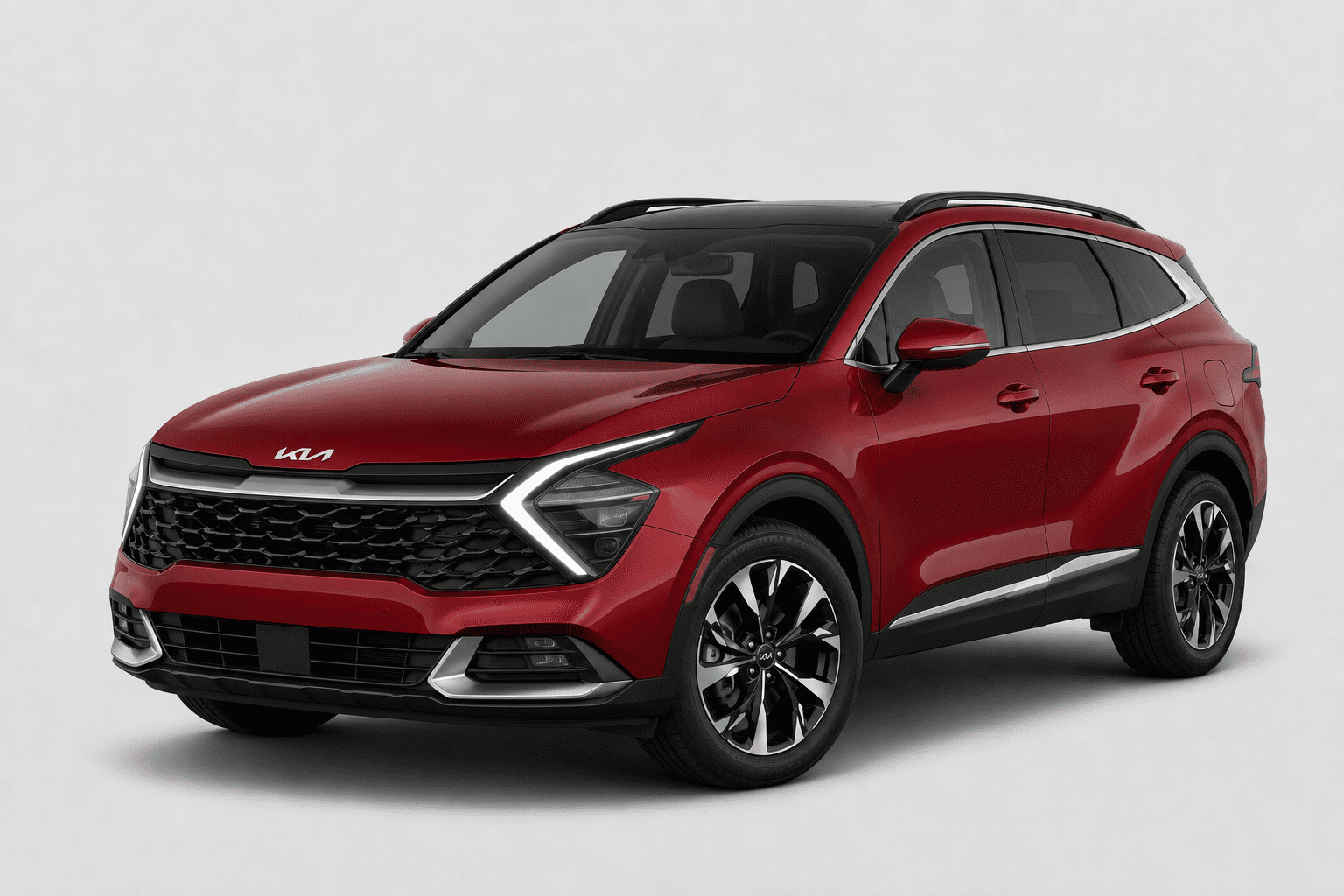 A red Kia Sportage SUV with a black roof and black multi-spoke wheels, photographed from a three-quarter front angle against a light gray studio background.