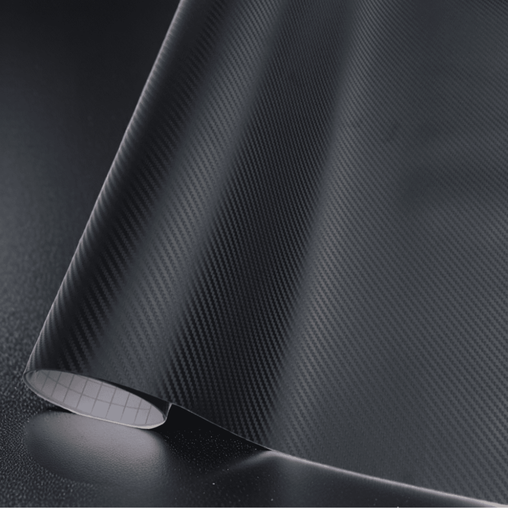 A roll of ChroMorpher black carbon fiber vinyl wrap, showcasing a detailed and realistic 3D carbon fiber texture, ideal for adding a sleek and modern finish to vehicles and various surfaces.