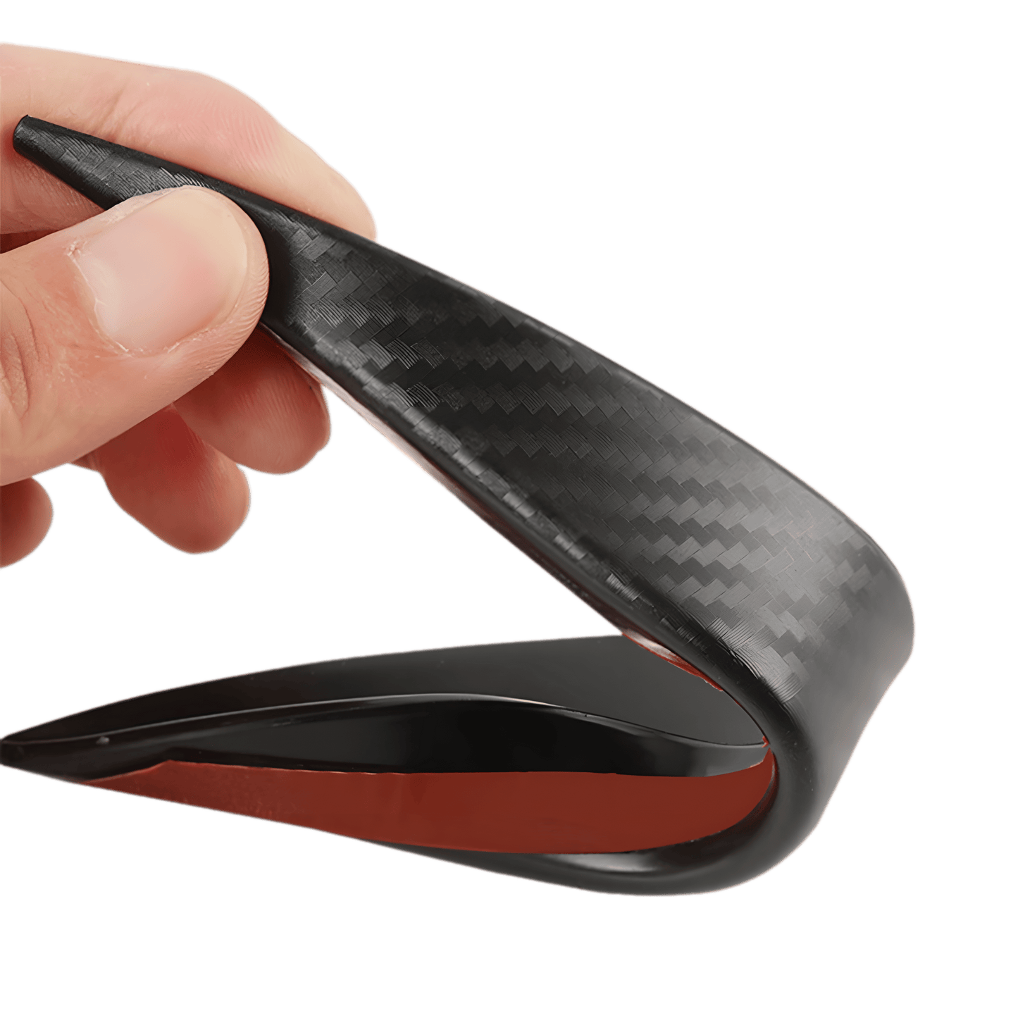 A close-up of a ChroMorpher carbon fiber-style rear bumper diffuser fin being slightly bent by hand, showcasing its flexibility, durability, and high-quality ABS material. The red adhesive backing ensures easy installation, making it a perfect addition for enhancing a vehicle's sporty look.