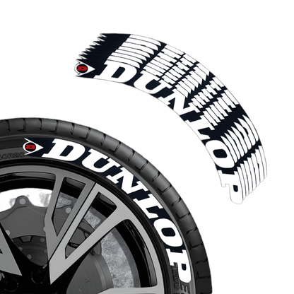A close-up of a ChroMorpher Dunlop Tire Lettering Kit, featuring bold white Dunlop branding with a unique tread pattern design on a black tire. The decal set is designed for performance vehicles and racing enthusiasts, adding a professional and stylish touch to any car.