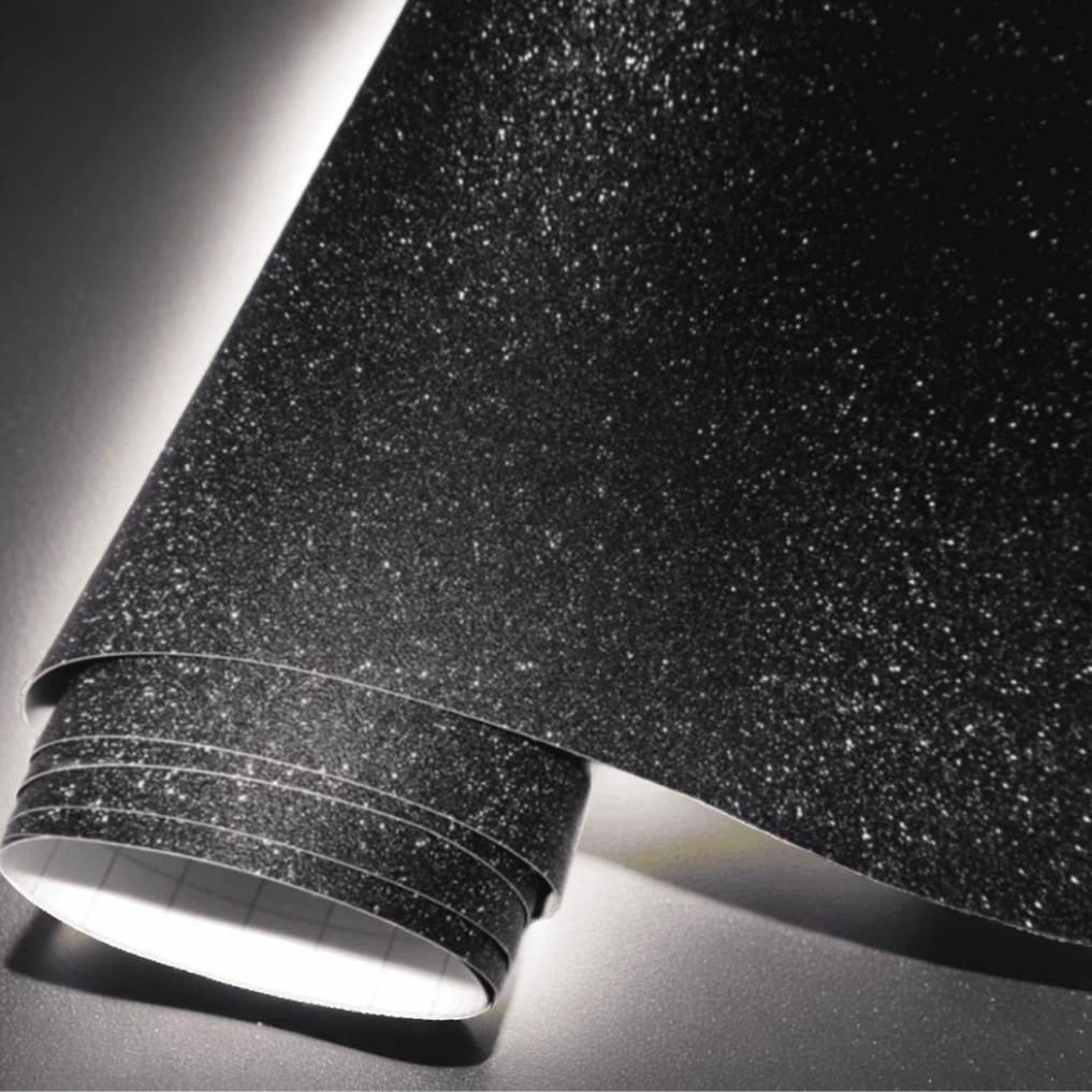 A roll of ChroMorpher black vinyl wrap with a glitter texture, offering a sparkling and luxurious finish

perfect for customizing vehicles, furniture, and other surfaces. Ideal for a bold, eye-catching design.