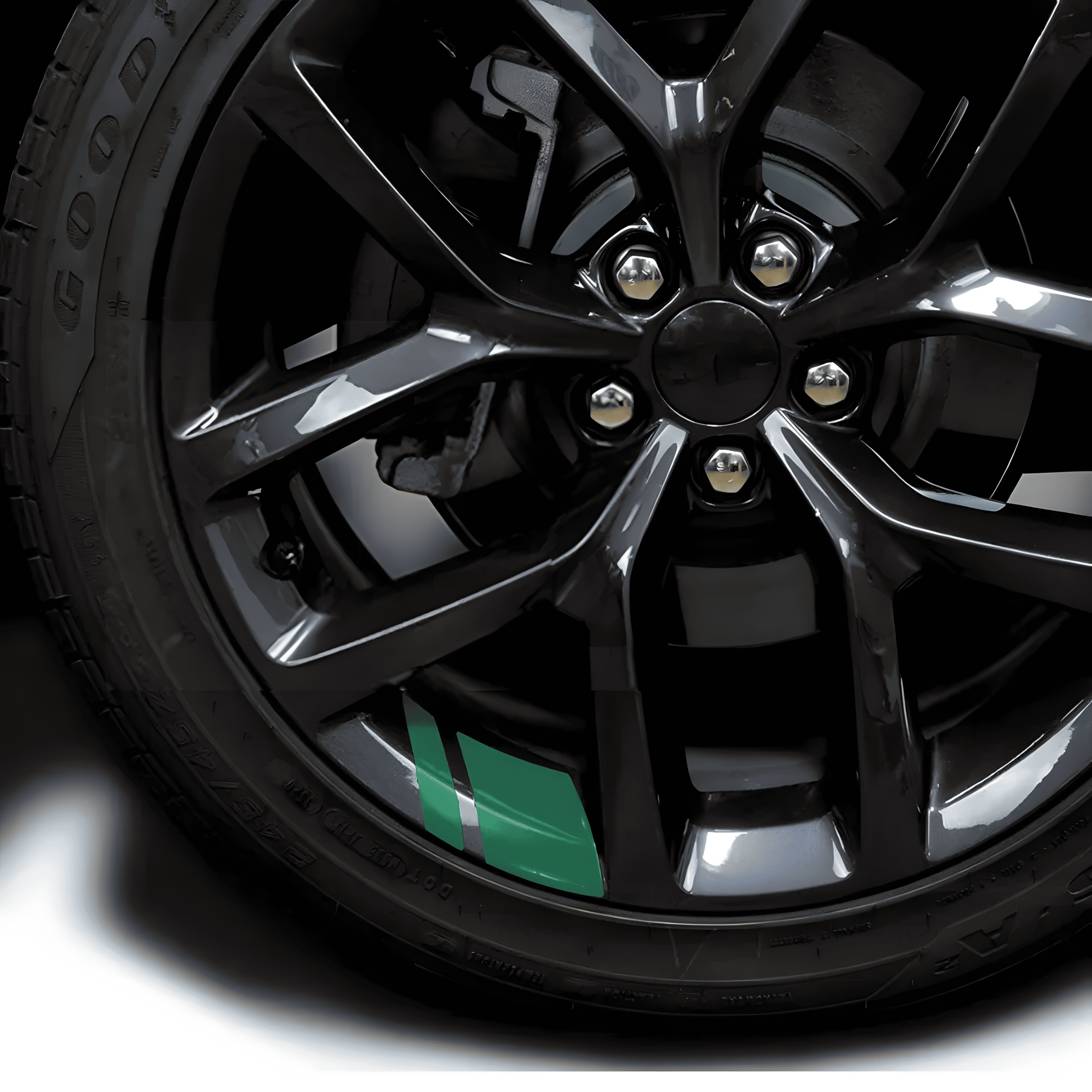 A sleek green reflective rim decal strip applied to a black alloy wheel, adding a stylish and sporty touch. These waterproof and durable stickers enhance visibility and aesthetics, fitting 18'' - 21'' rims for a universal and easy-to-apply upgrade to cars and motorcycles.