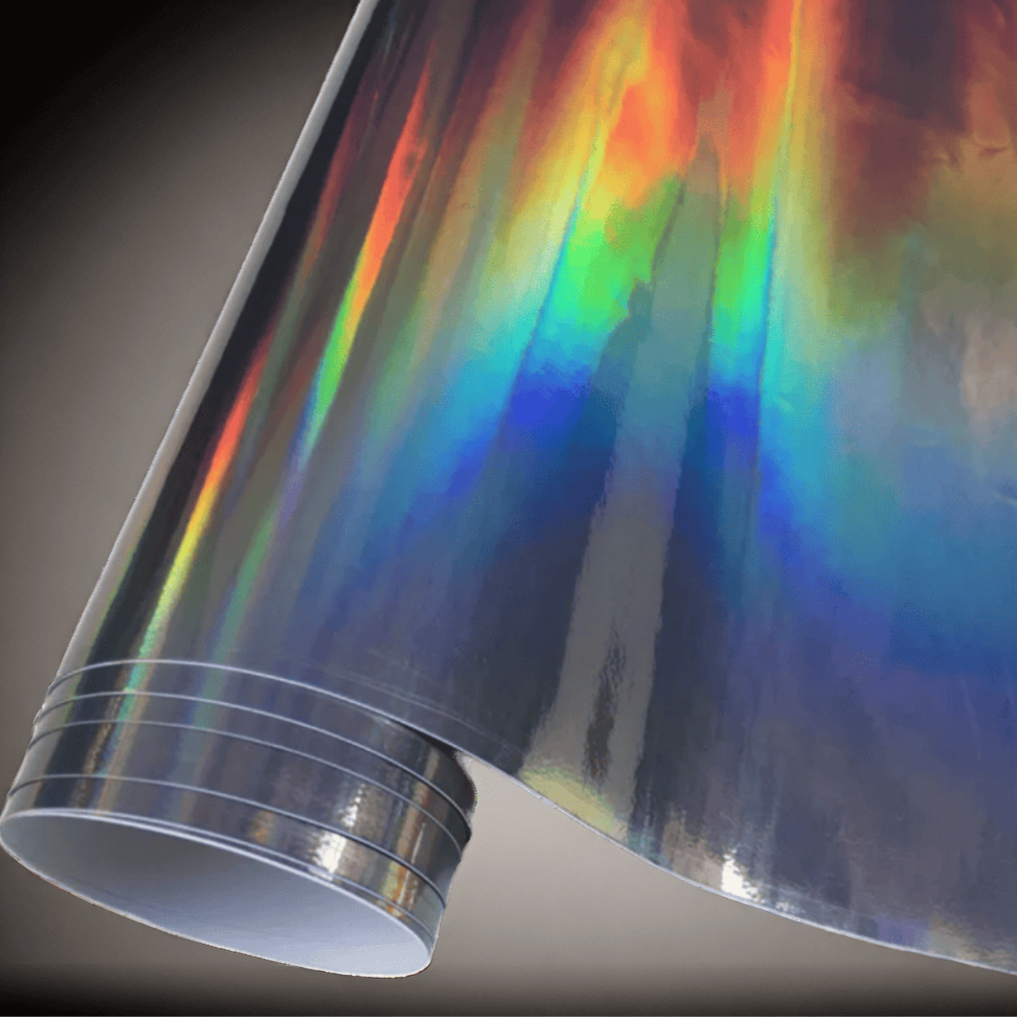 A roll of ChroMorpher holographic vinyl wrap, showcasing a vibrant rainbow effect that shifts with light, perfect for creating a bold and eye-catching finish on vehicles and various surfaces.