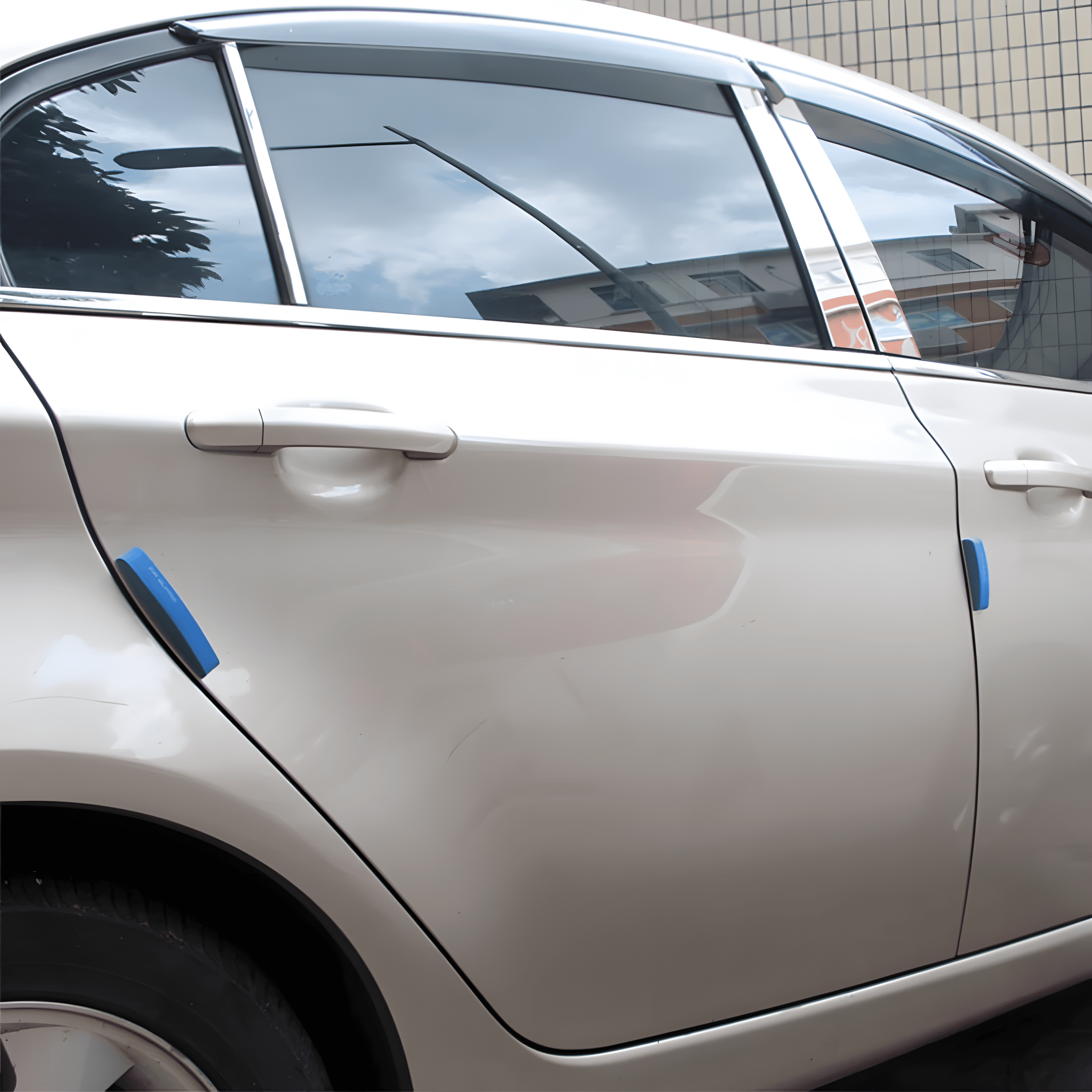 A close-up of a vehicle door with ChroMorpher Protective FR Guard Car Mouldings applied in blue on the front and rear areas, providing protection from scratches and minor bumps while enhancing the vehicle's appearance.