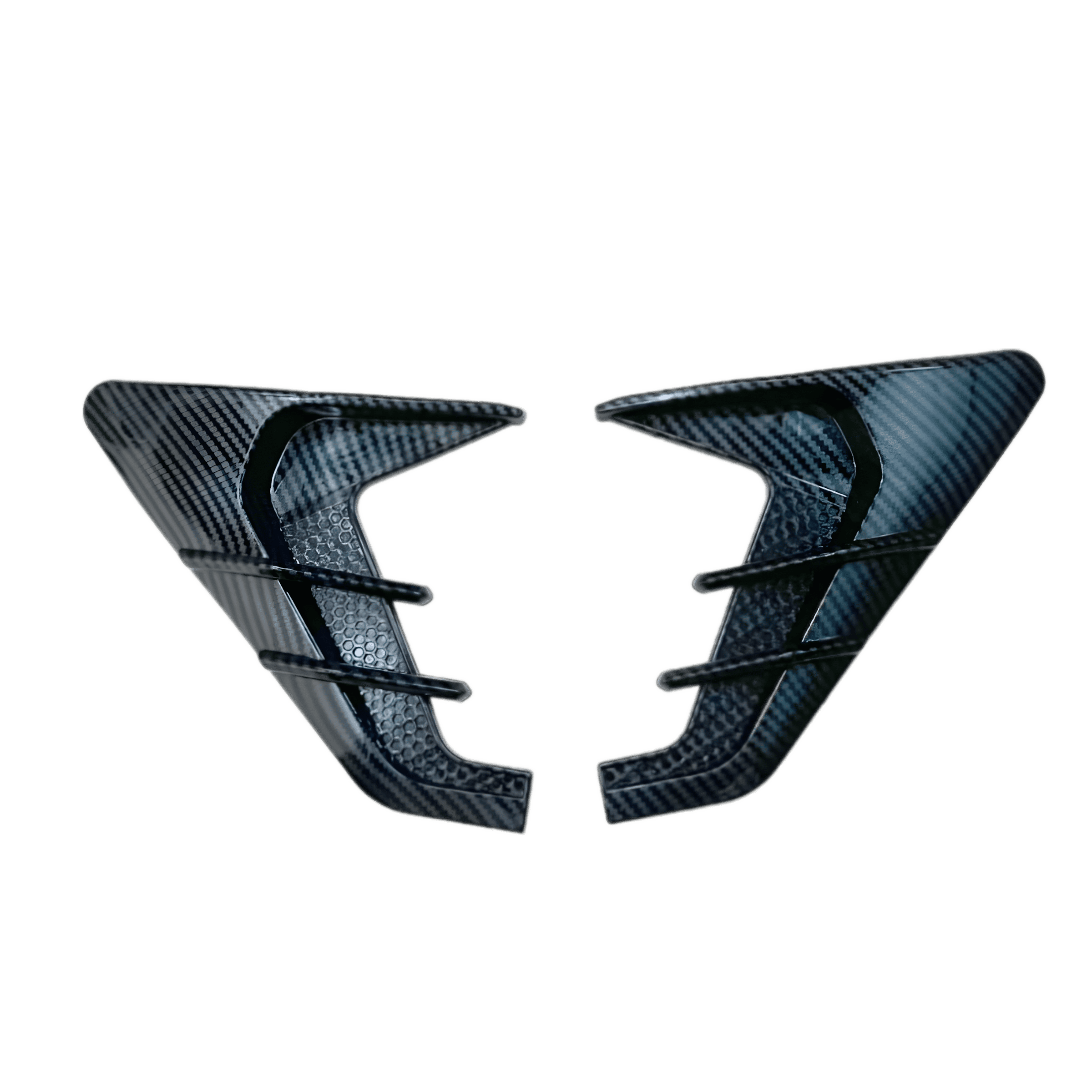 A pair of ChroMorpher Side Fender Vents in a Carbon Look finish, displayed on a transparent background. These vents feature a detailed carbon fiber pattern for a sleek, high-performance aesthetic. Designed to enhance the vehicle's aggressive and sporty appearance, they are made from durable, weatherproof rubber for long-lasting performance. The textured honeycomb details add depth to the design, making them a stylish upgrade for any car. With a self-adhesive backing, they allow for easy, drill-free installa