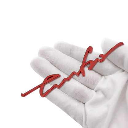 A red "Turbo" 3D emblem badge held in a hand, showcasing its high-quality zinc alloy material. This self-adhesive car sticker is perfect for adding a stylish and sporty accent to any vehicle. Ideal for exterior and interior placement, it provides a durable, sleek, and eye-catching look to your car body, windows, or bumpers.