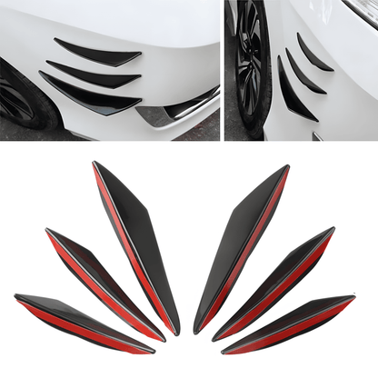 A 6-piece universal rear bumper spoiler diffuser kit in sleek black with red adhesive backing, designed to enhance a car’s aerodynamics and appearance. The image showcases the diffusers installed on a white vehicle's rear bumper, adding an aggressive, sporty look.