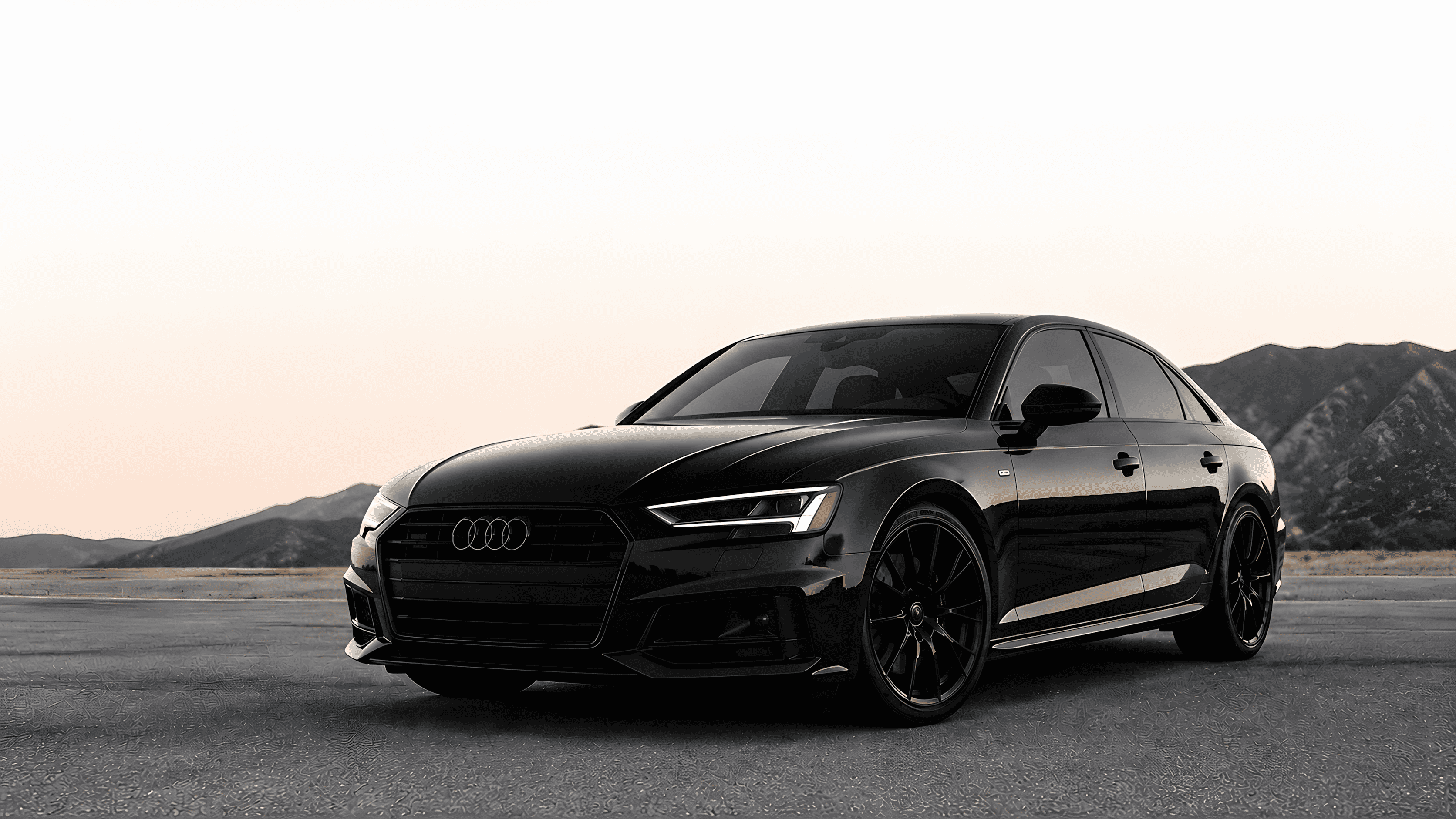 Black Audi car on a road with mountains in the background