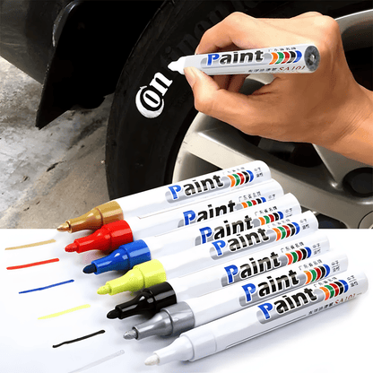 A set of multi-color paint pens designed for tire lettering and customization, featuring white, red, blue, yellow, black, silver, and gold options. The top half of the image shows a hand using the white paint pen to apply text on a black tire, demonstrating its smooth, waterproof, and durable application. Ideal for cars, motorcycles, and bicycles to create a custom tire design with lasting results.