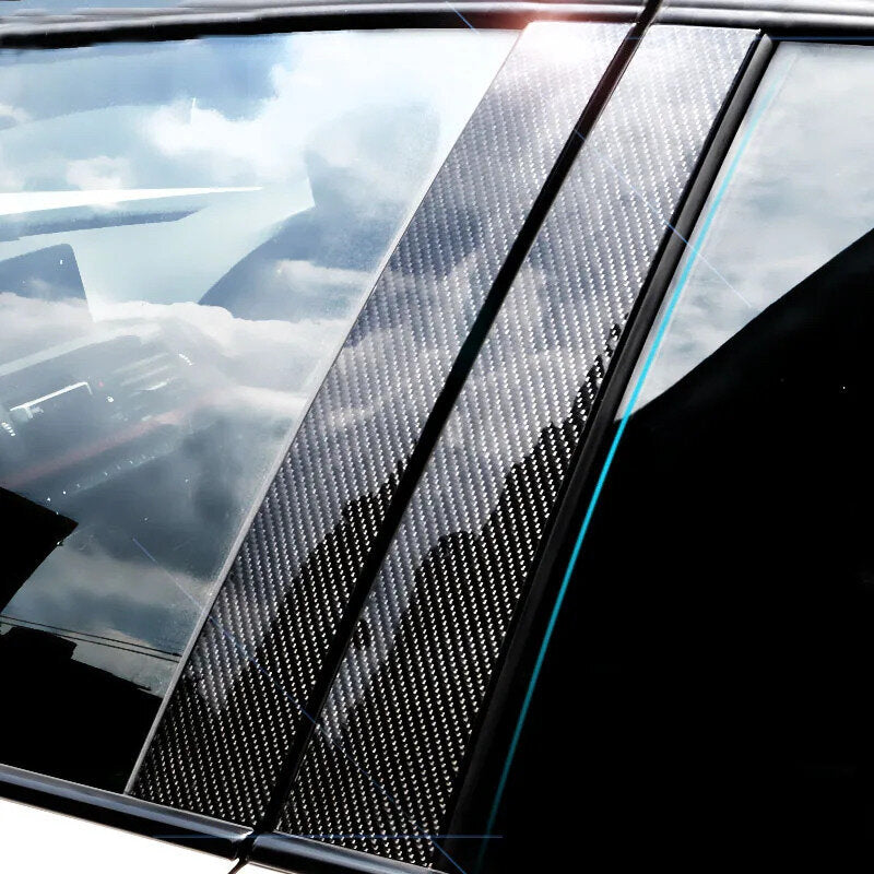 Close-up of a car window with a ChroMorpher carbon fiber vinyl wrap applied to the chrome trim, reflecting sunlight.