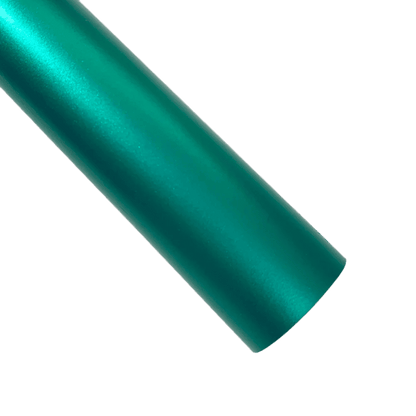 A vibrant teal ChroMorpher Ice Matte Vinyl roll with a satin matte chrome finish, ideal for car wraps and creative projects, displayed against a textured dark surface with soft lighting.