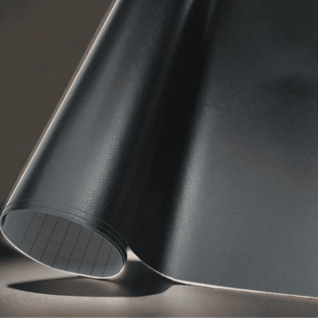 A close-up of ChroMorpher black vinyl wrap featuring a realistic leather-like texture, perfect for adding a luxurious and durable finish to vehicles, furniture, and other surfaces.