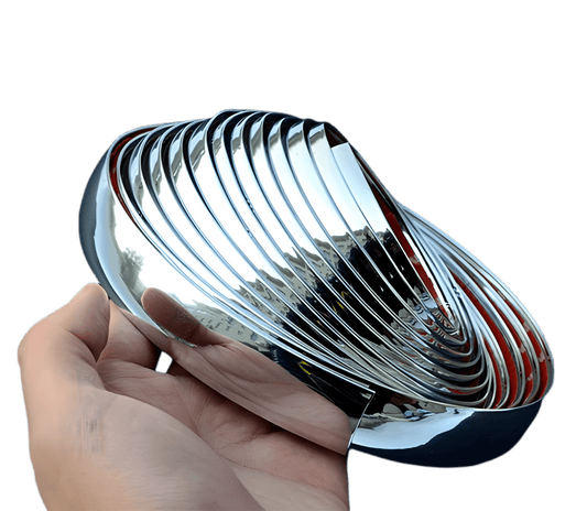 Hand holding a glossy chrome ChroMorpher Clip-On Trim Cover 2.0 roll showing the reflective mirror finish and flexible design