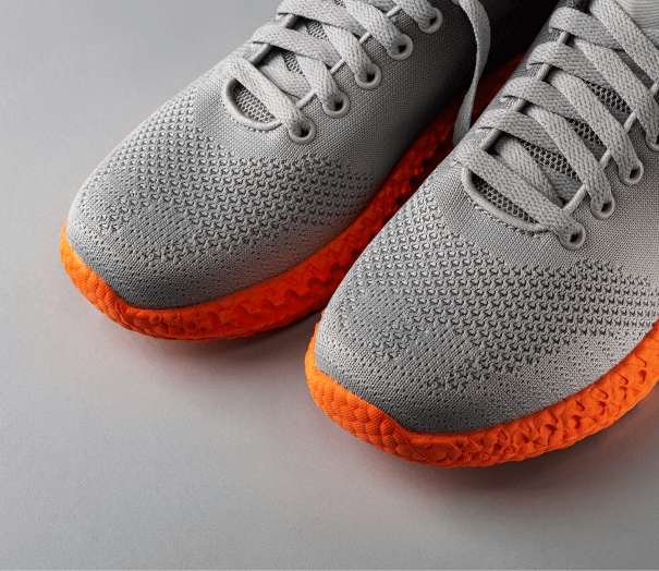 Side view of a white Mercedes-Benz coupe with black alloy wheels and green brake calipers, parked in an industrial setting.