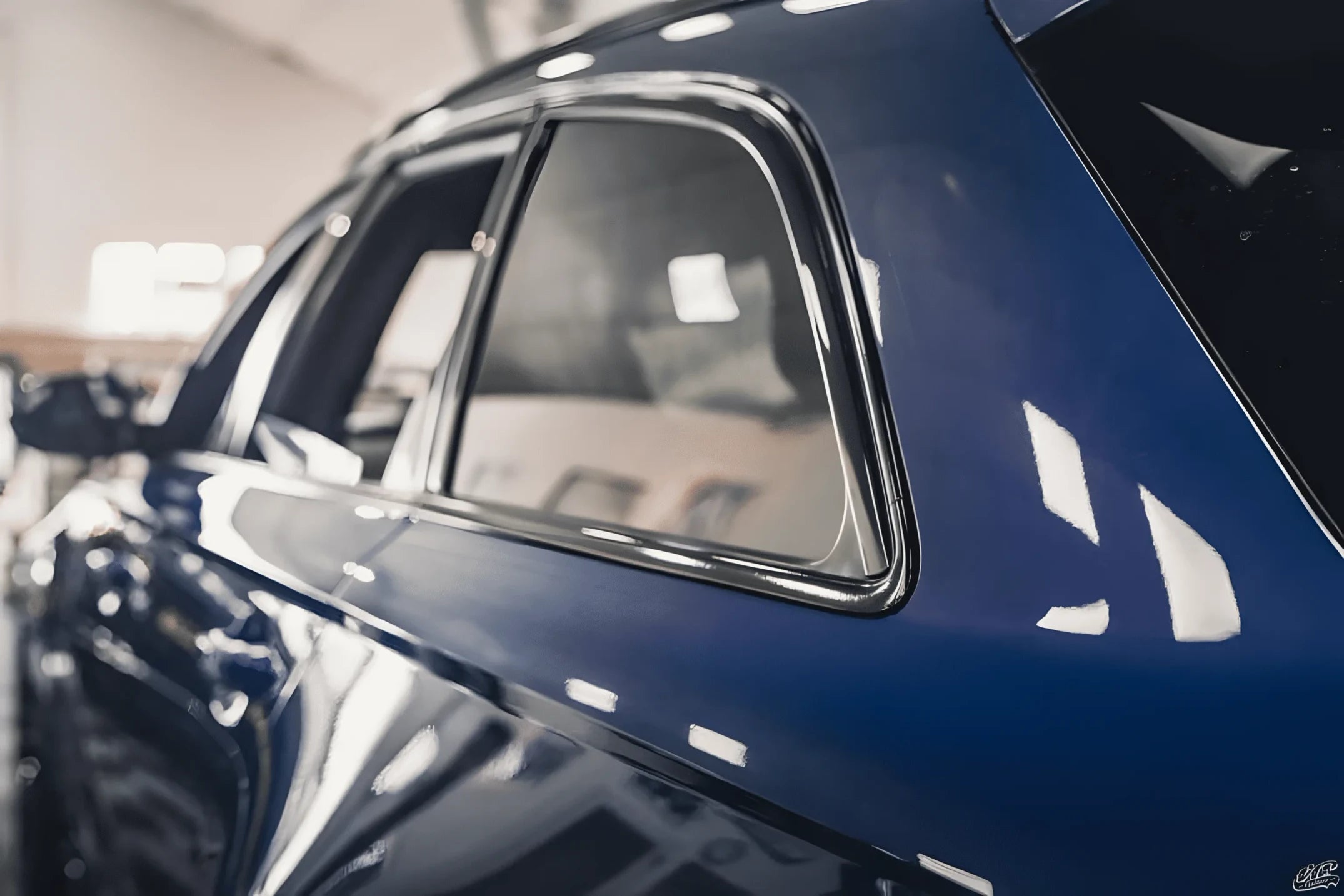 Close-up of chrome window trim on a blue car before applying ChroMorpher Chrome Delete Tape.