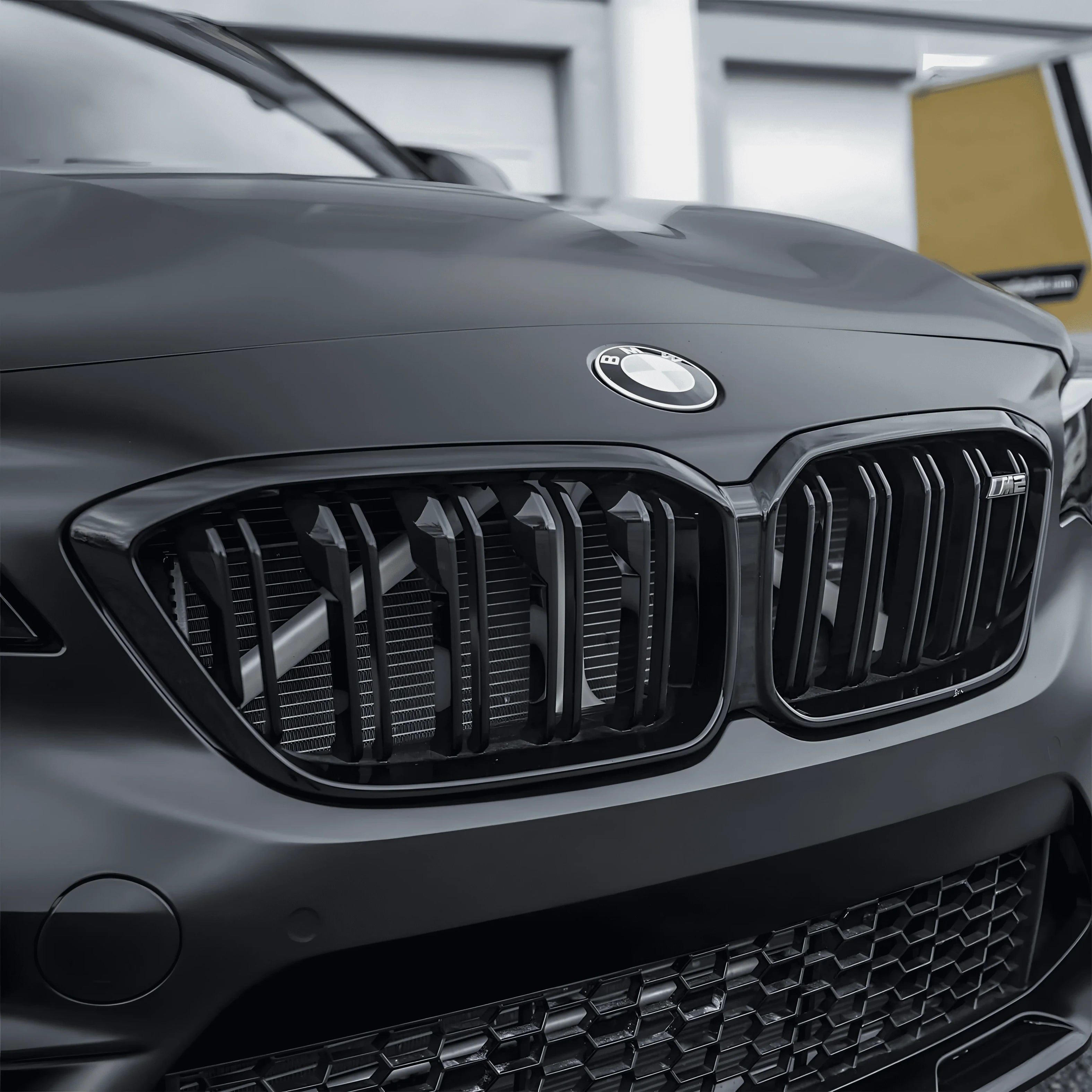 Close-up of BMW kidney grille wrapped with ChroMorpher Matte Black Chrome Delete Tape for a full blackout look.