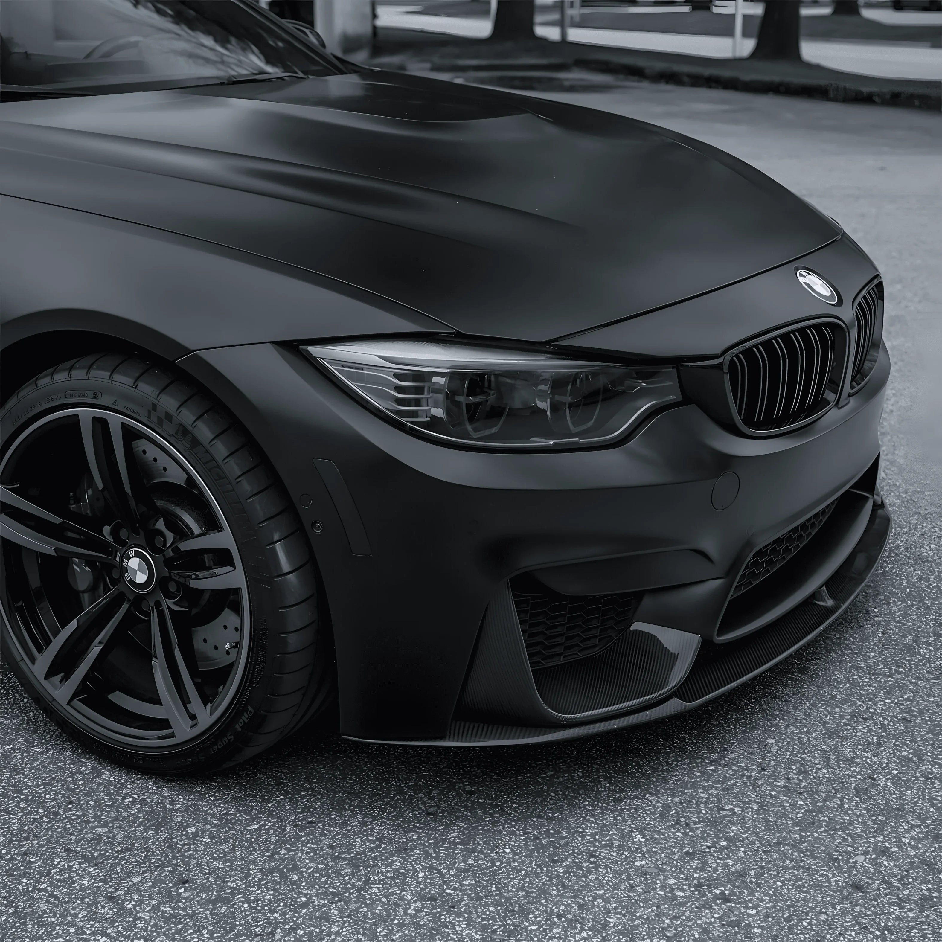 BMW sedan front view wrapped with ChroMorpher Matte Black Chrome Delete Tape for a sleek blackout finish.