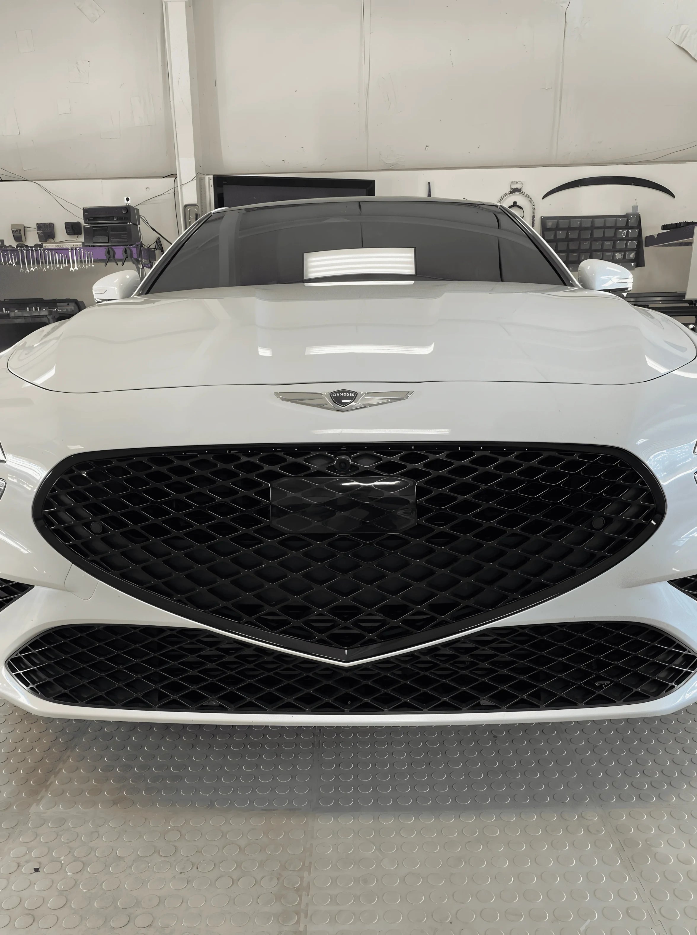 Front view of white Genesis sedan with blacked-out grille using ChroMorpher Glossy Chrome Delete Tape.