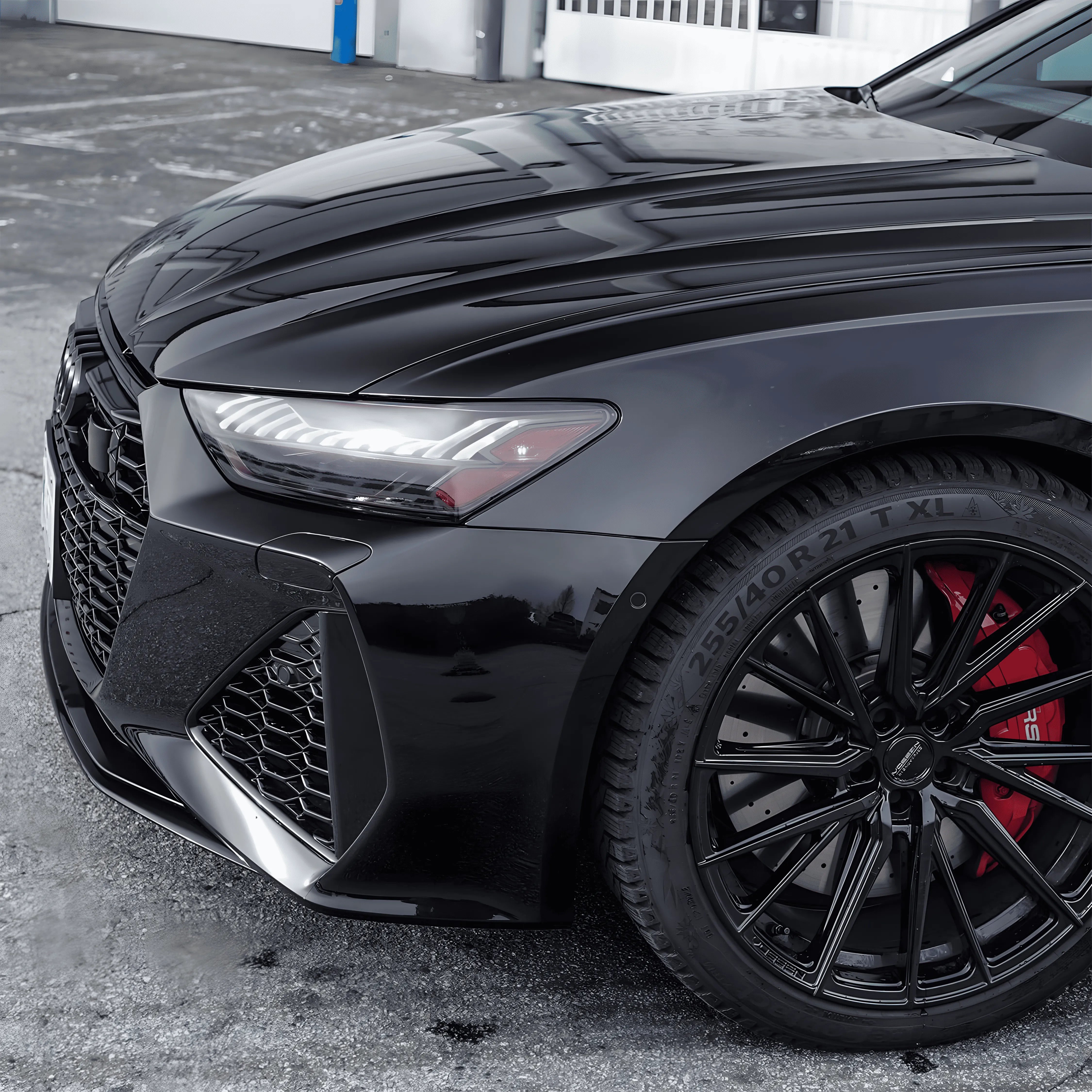 Audi front fender, grille, and window trim with ChroMorpher Glossy Black Chrome Delete Tape and black alloy wheels.