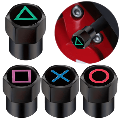 A set of four black aluminum tire valve caps featuring gaming-inspired button symbols: green triangle, red circle, blue X, and pink square. One cap is shown installed on a vehicle's valve stem, highlighting its sleek design. These durable, dustproof, and leak-proof valve caps provide a stylish upgrade for cars, motorcycles, bicycles, and other vehicles.