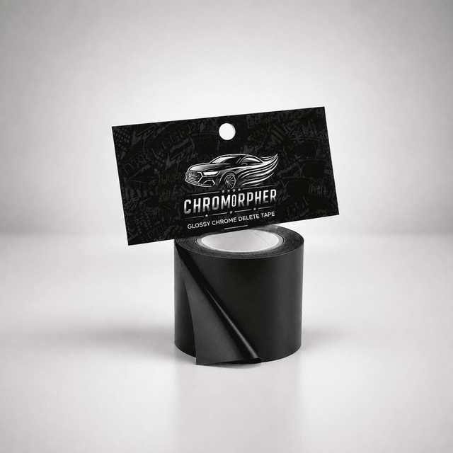 A roll of black glossy chrome delete tape with its black hanging card packaging, featuring the brand name 'CHROMORPHER' and a car graphic, set against a light gray studio background.