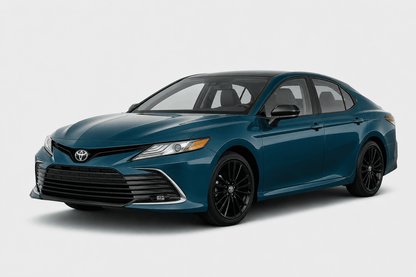 A dark teal blue Toyota Camry sedan with black wheels, shown from a three-quarter front angle on a light gray studio background.