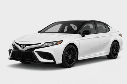 A white Toyota Camry sedan with black accents, including the roof, side mirrors, and wheels, shown from a three-quarter front angle on a light gray studio background.