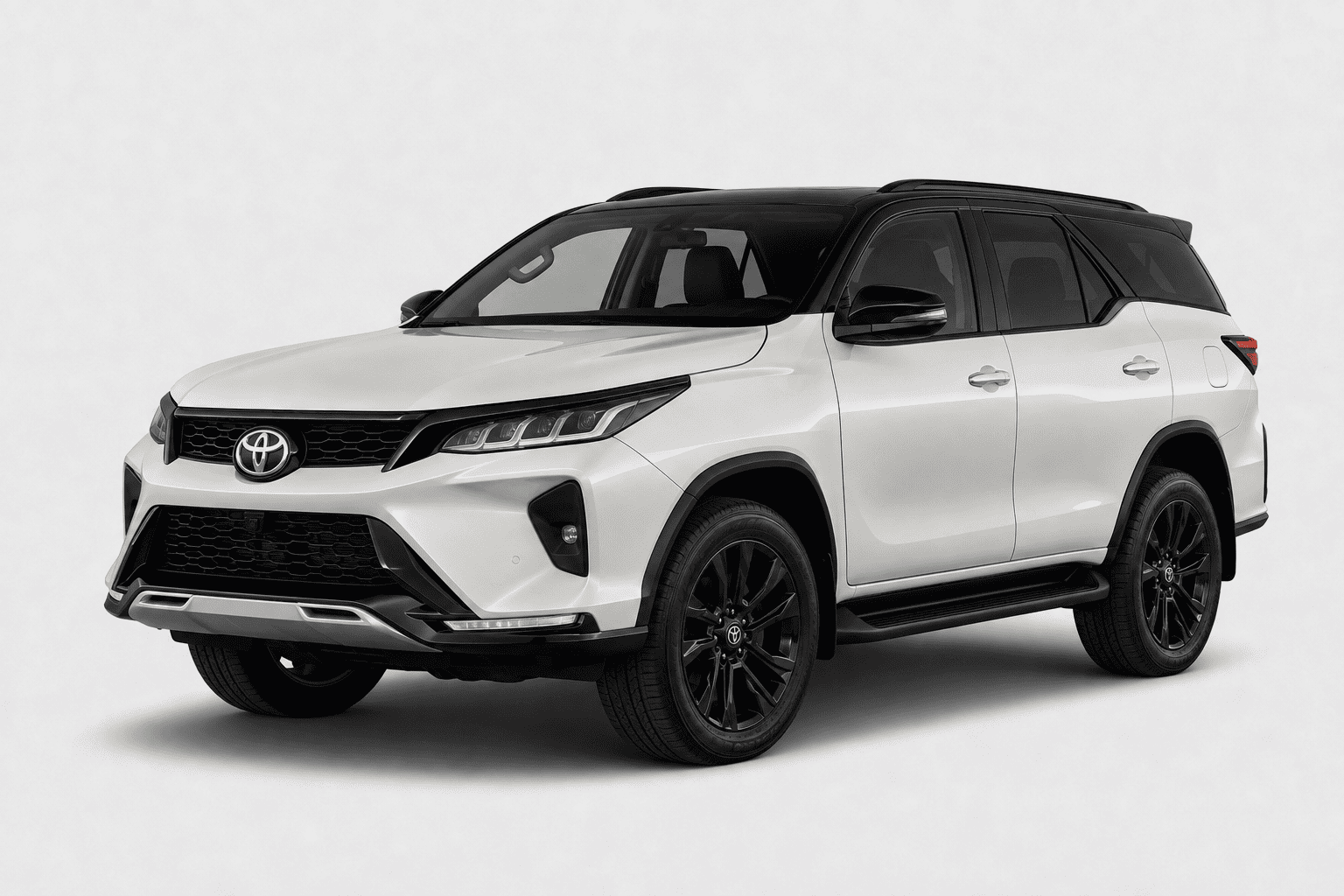 A white Toyota Fortuner SUV with black accents, including the roof, wheels, and trim, shown from a three-quarter front angle on a light gray background.