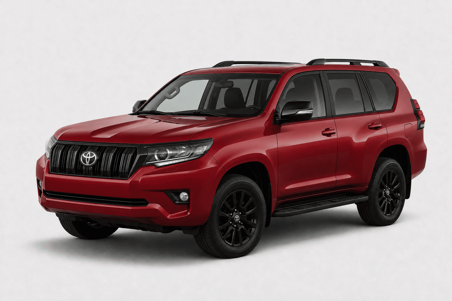 A red Toyota Land Cruiser SUV with black wheels and roof rails, photographed from a three-quarter front angle on a light gray studio background.