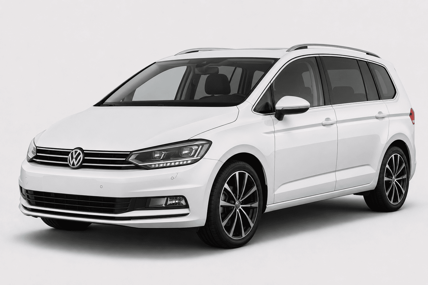 A white Volkswagen Sharan minivan shown from a three-quarter front angle on a light gray studio background.